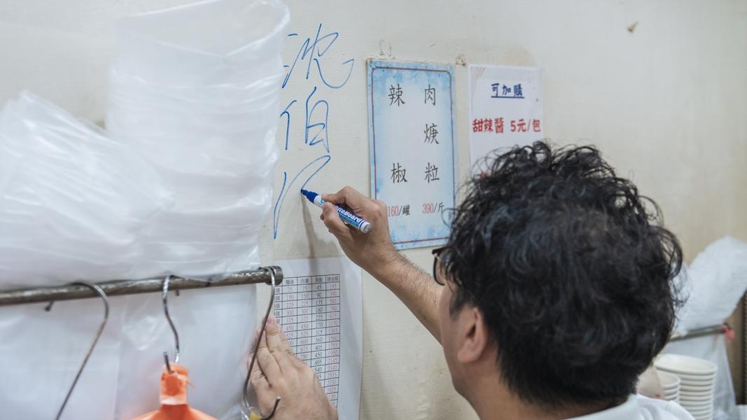 沈伯洋簽名在店家牆上。(圖/沈伯洋競辦提供)