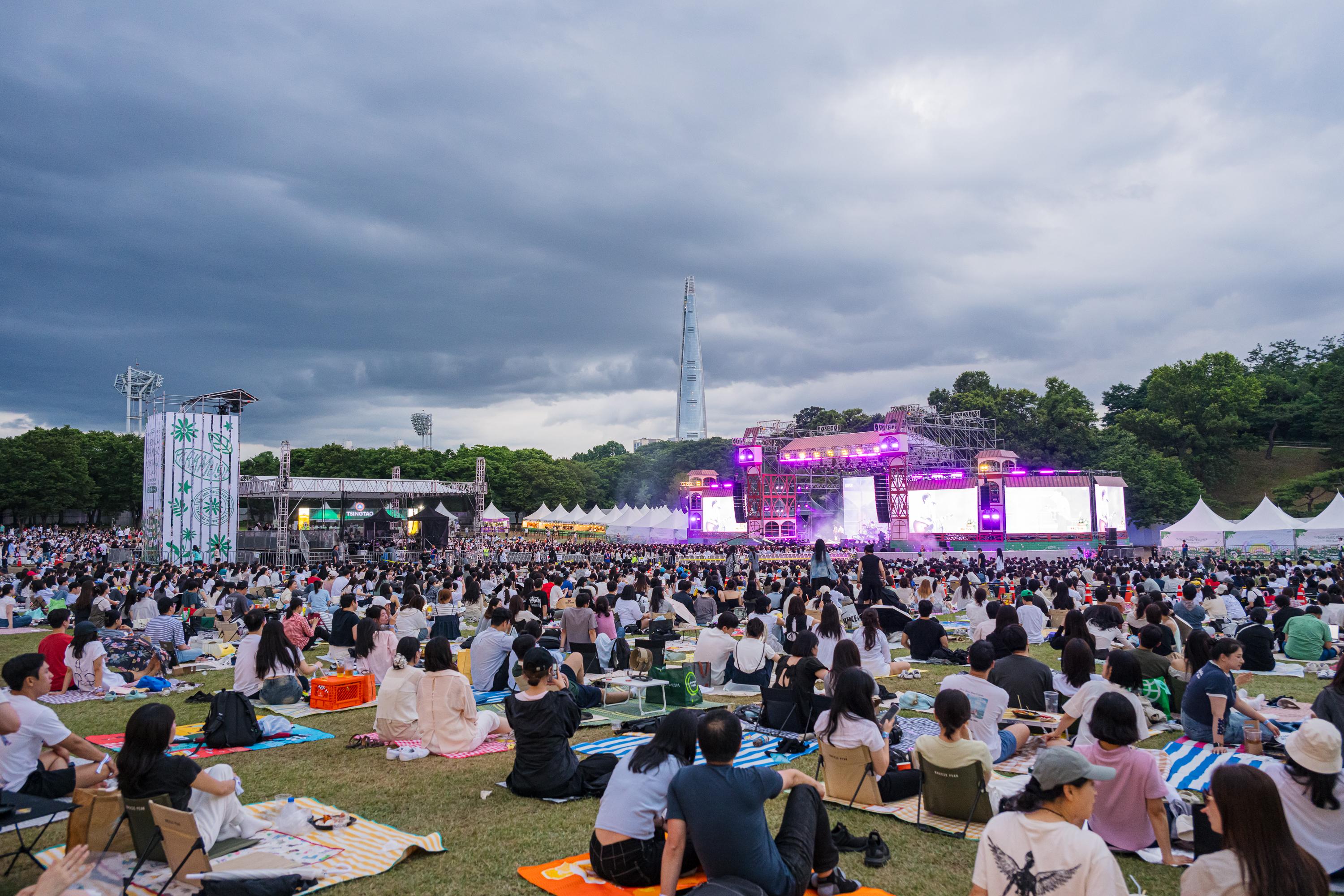 鋪墊席地聽歌,首爾公園音樂節已成當地樂迷最期待的夏日風景。(圖/CJ ENM Hong Kong Ltd.提供)