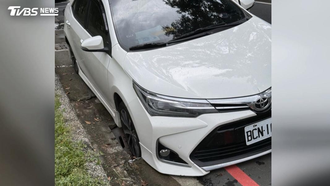 高雄中央公園旁水溝蓋底座脆化,轎車輾過時突然整個輪胎陷進去,導致車輛卡住動彈不得。(圖/翻攝Threads@0106_hao)(圖/其他)
