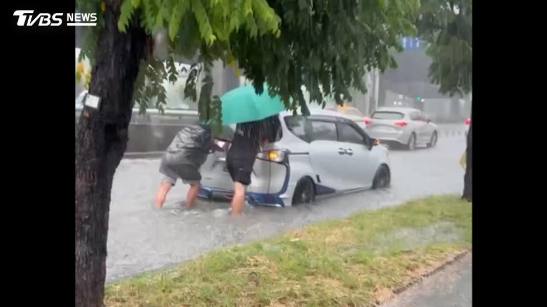 (豪雨特報! 台中環中路"積水刁車" 民眾穿垃圾袋冒雨推車。圖/threads1012_shang 精速洗)