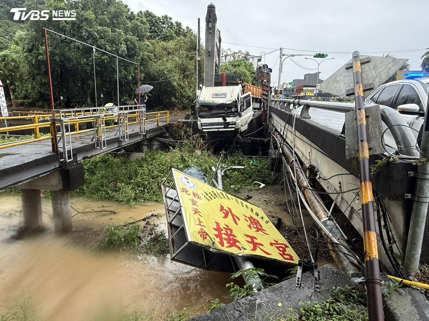 砂石車疑似雨天打滑煞不住自撞，還撞斷接天宮指示牌。（圖／TVBS）