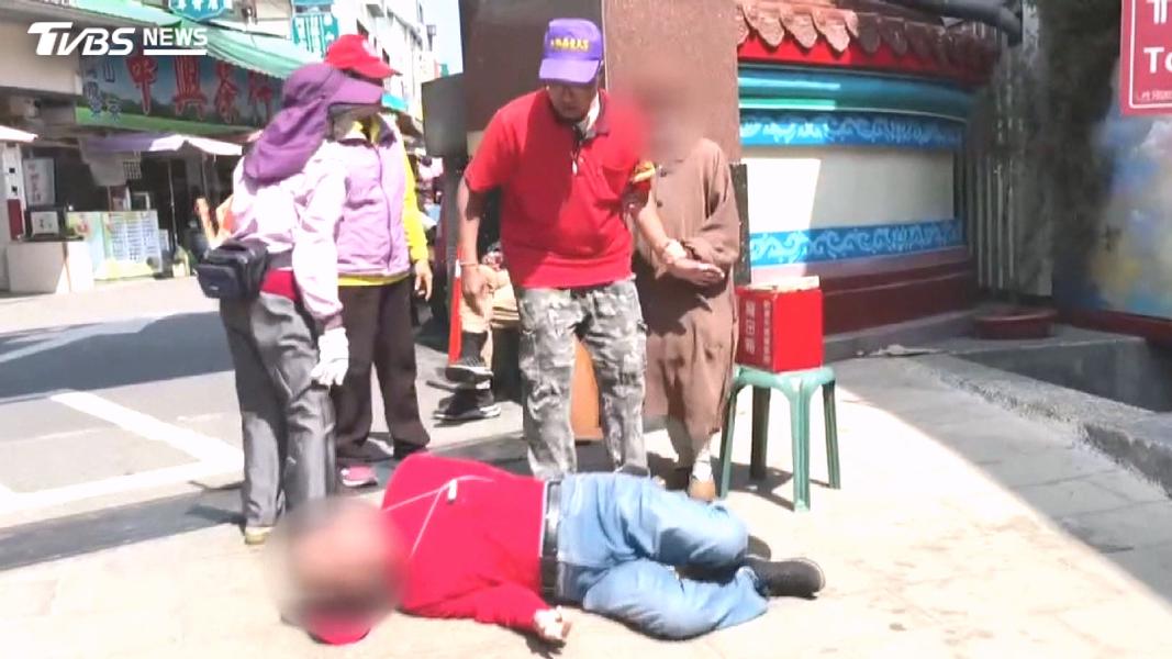 一名比丘尼因不滿志工在牌樓處管制人車,竟拿起紅色功德箱痛砸志工。(圖/TVBS)