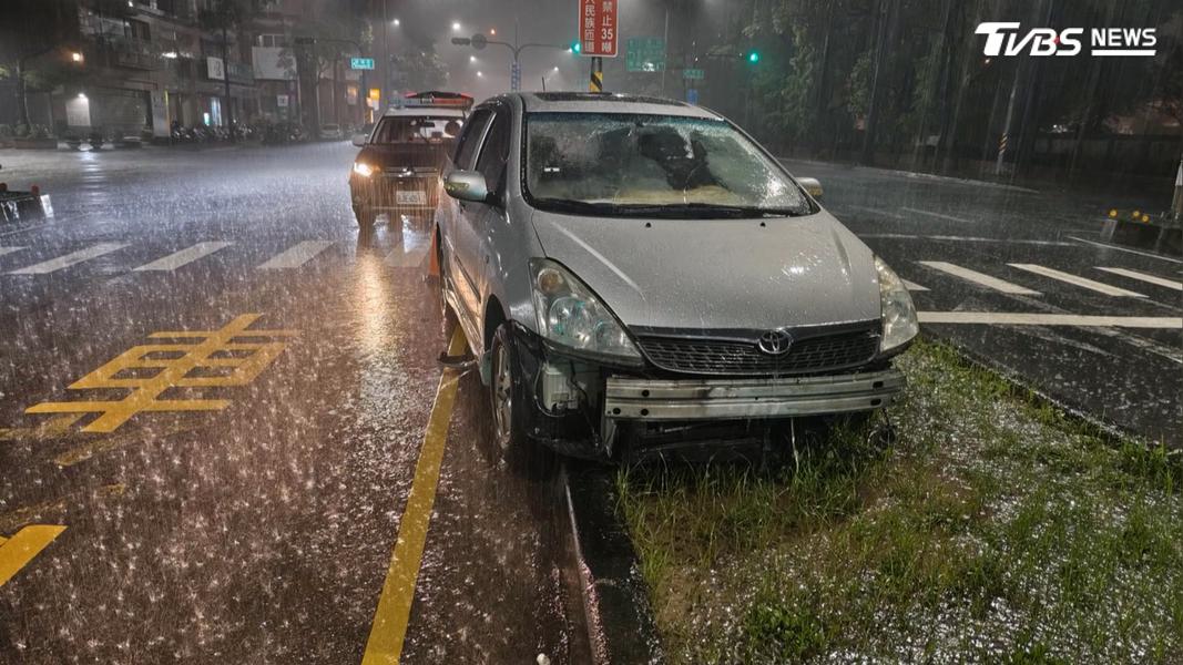 一輛小客車自撞分隔島後自行離去,警方只好找來吊車將車輛先移到路邊。(圖/TVBS)