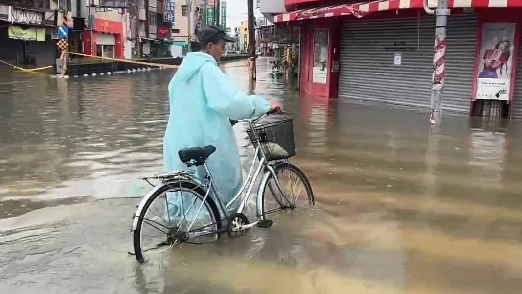 台南暴雨阿伯無奈地牽著腳踏車(圖/TVBS)
