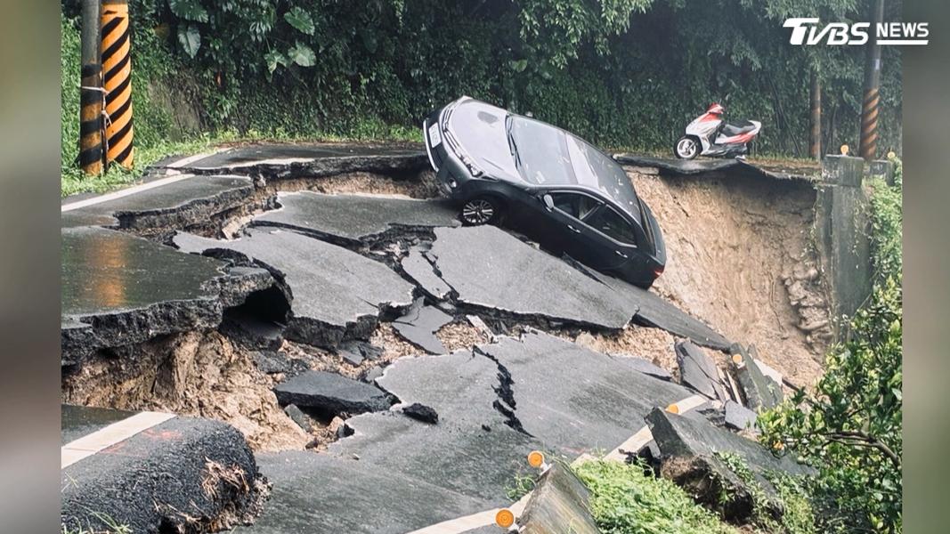 台南六甲東高蚋南115線1.6K處整條路面坍方滑落,一輛黑色轎車差一點就掉落山坡,卡在半路嚴重傾斜(圖/TVBS)