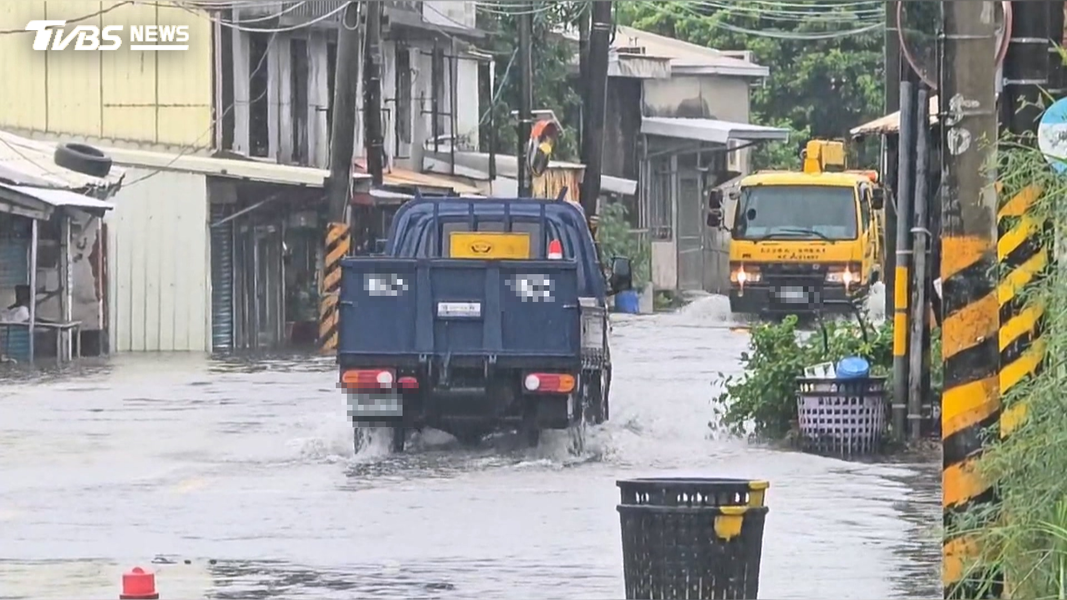 小貨車行駛過淹水路段,不只濺起大量水花,強勁的水波通通往民宅裡面灌,其中一間的鐵門被撞壞(圖/TVBS)