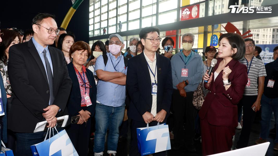 TVBS主播彭惠筠(右一)帶臺中市副市長鄭新照(左一)到交流區域並看機器人動態展示。(圖/華子琛攝)
