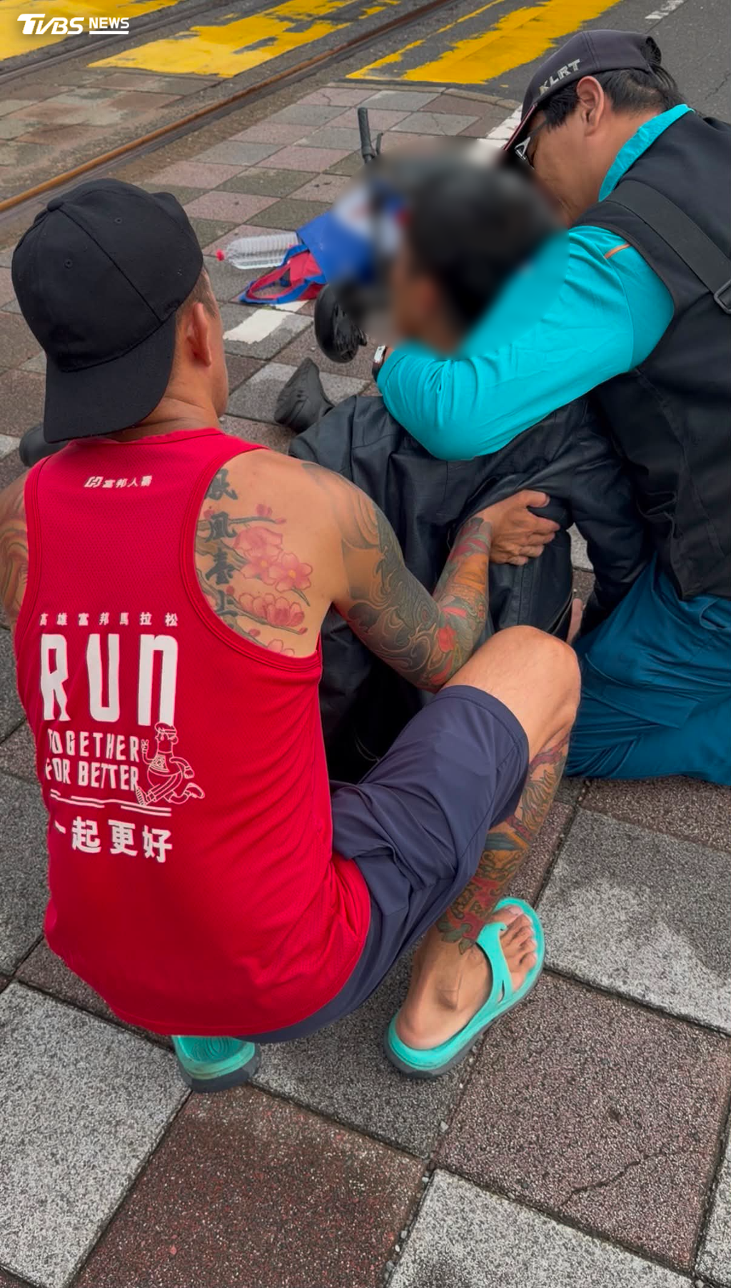 身穿紅色背心的男子最先發現狀況，立刻上前攙扶查看，輕軌人員也第一時間便主動攜帶AED設備前往協助，所幸救護人員及時抵達接手處理，順利結束這場驚魂意外。（圖／翻攝 threads@lin___ming）