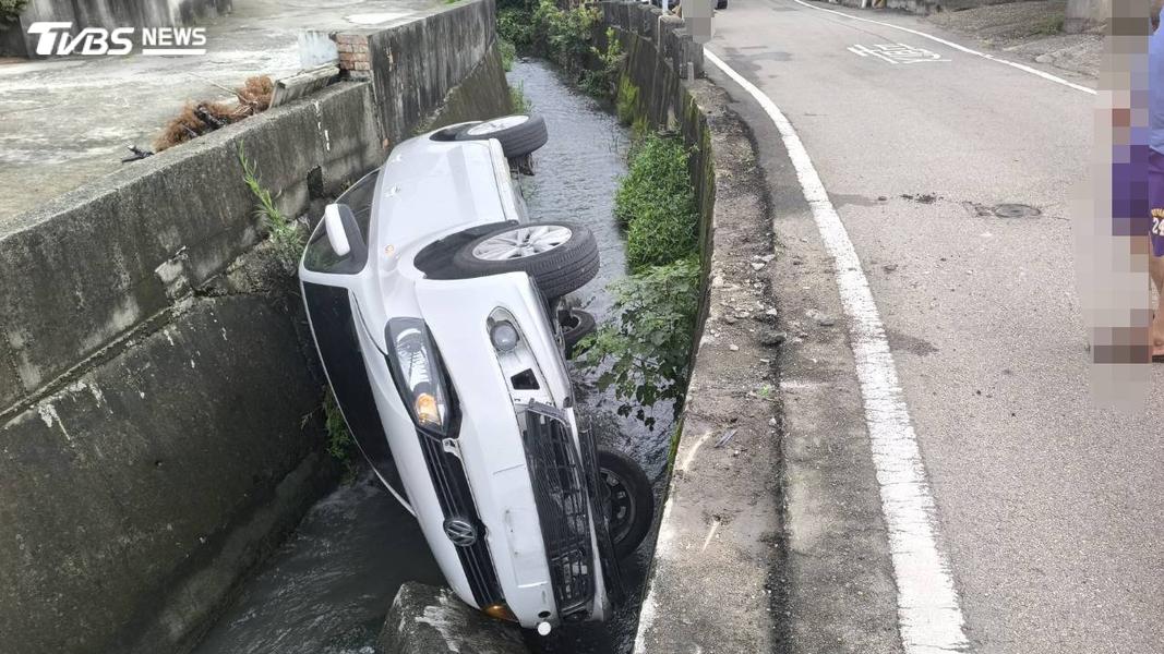 台中清水區27日上午7點多,小客車才剛通過路口,隨即整輛車側翻落入路邊大排,在民眾拍攝影片前,車上連同駕駛共三人已被送醫治療(圖/TVBS)
