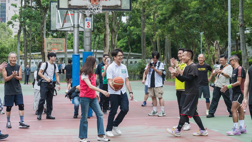 民進黨台北市長參選人沈伯洋28日上午前往象山公園拜票,還與民眾一起打籃球。(圖/沈伯洋競辦提供)