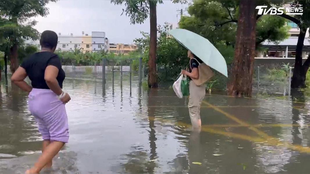積水已深及成人小腿肚,整座校園宛如孤島,想進入學校只能拉著褲管緩慢涉水前行(圖/TVBS)