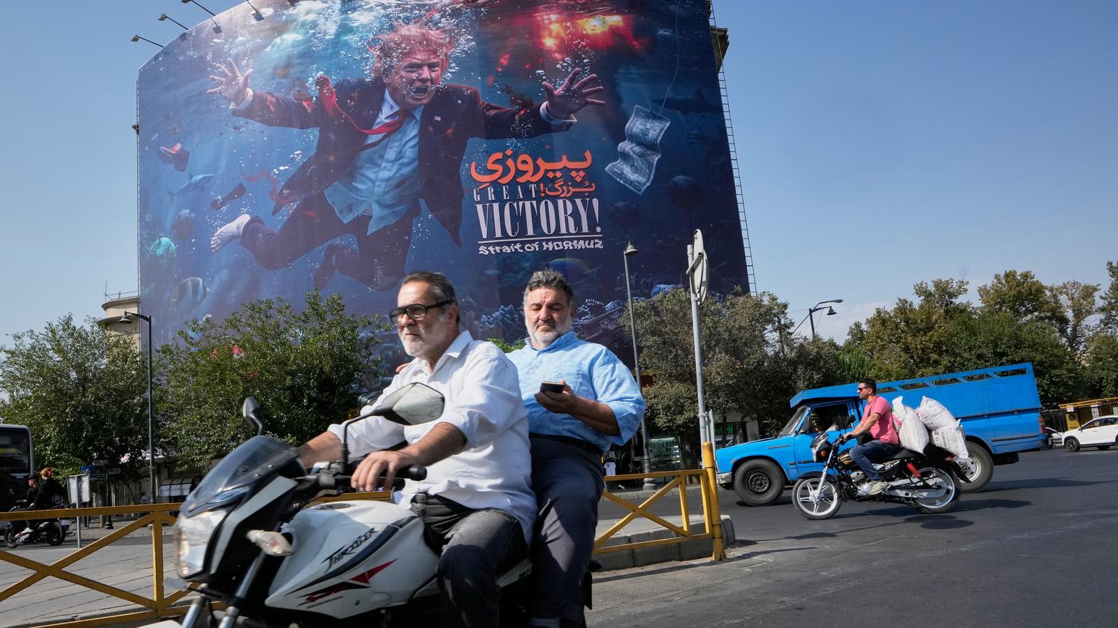 德黑蘭街頭看板寫著「Great Victory! Strait of Hormuz」,畫面合成美國總統川普沉入爆炸水中。(圖/美聯社)