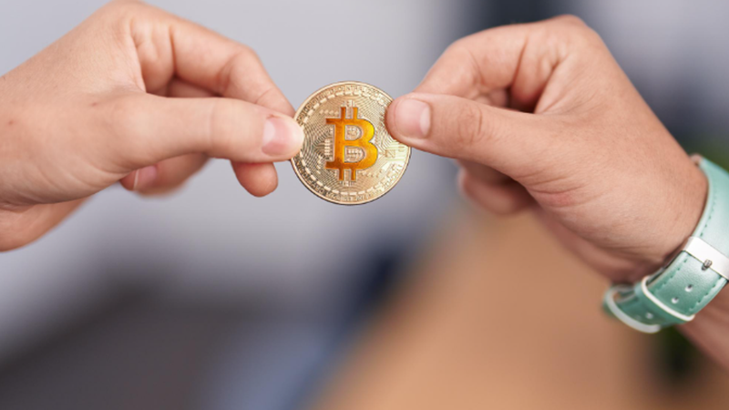 old man passing a bitcoin to a young man。(圖/magnific)
