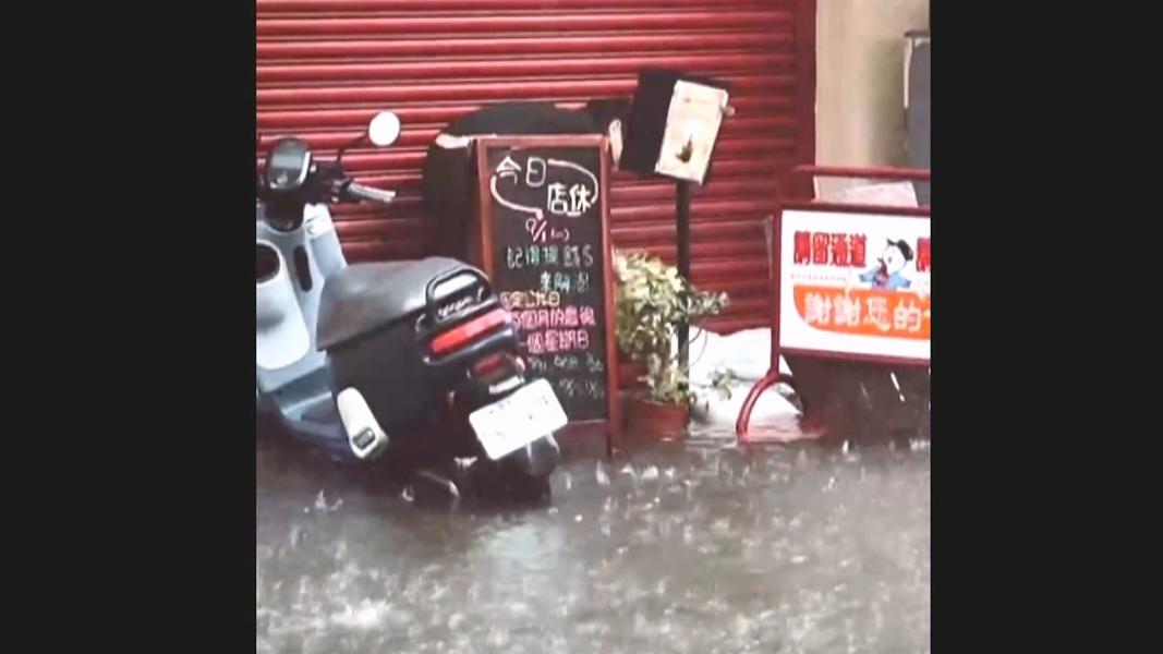暴雨淹馬路!奶茶店主人出遊 對面麵店老闆「涉水堆沙包」暖舉全錄下。(圖/民眾提供)