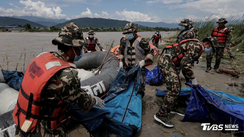 洪水過後,軍方人員將遺體裝入袋子內。(圖/達志影像路透社)