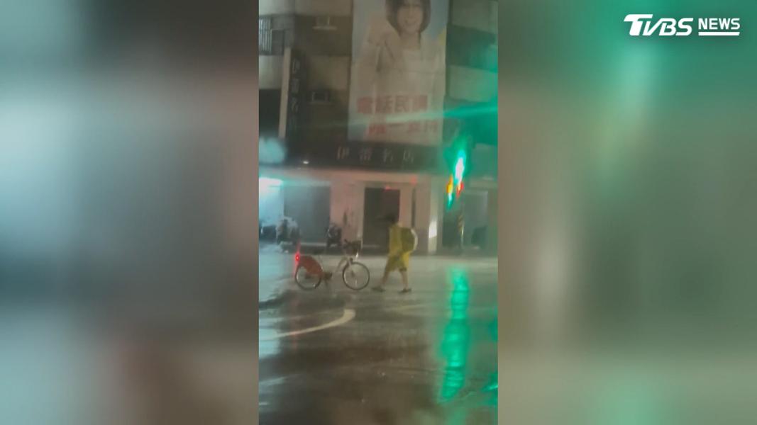 學生冒著大雨,將圍在大坑洞旁已經傾倒的三角錐扶起,有民眾看到將影片上傳網路,大力讚揚學生暖心的舉動(圖/翻攝Threads@ellie.19__)