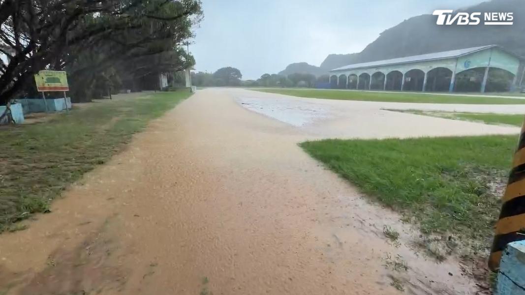 雖然雨勢趨緩但萬里國中操場跑道還是部分區域有積水。(圖/TVBS)