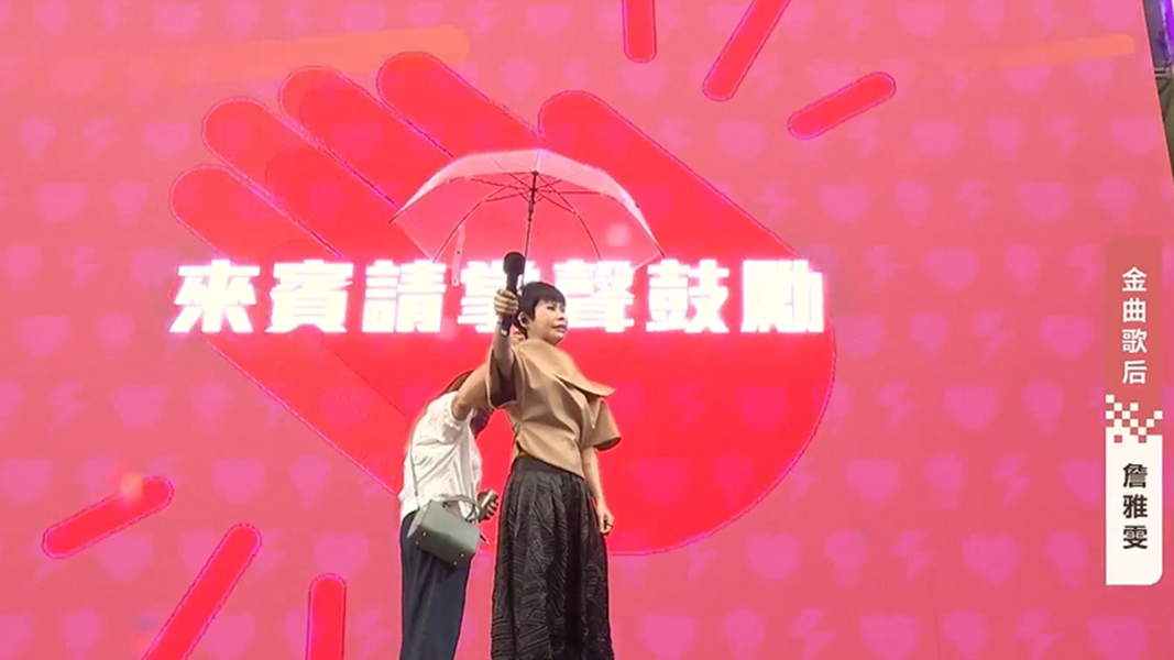 歌后詹雅雯撐傘獻唱,高喊「凍蒜」。(圖/翻攝蘇巧慧FB直播)