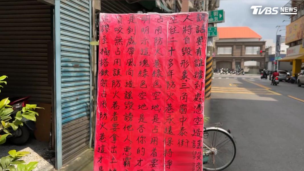 被指控的鄰長則擺出告示牌反擊,痛批對方惡意造謠。(圖/TVBS)
