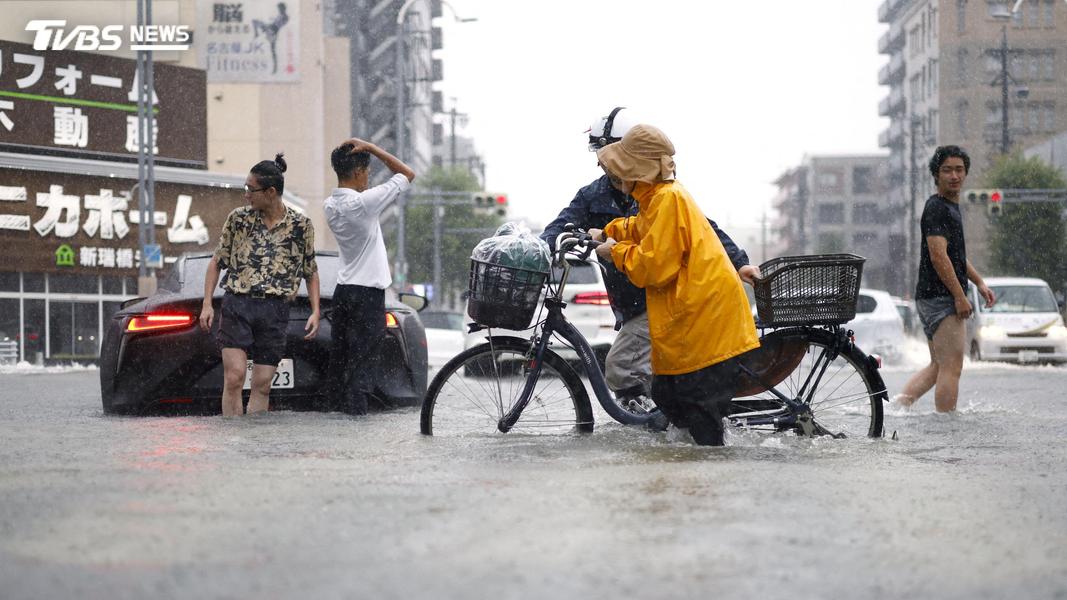 榮區市中心積水達膝蓋下方,路人只能提著褲管涉水。(圖/達志影像路透社)