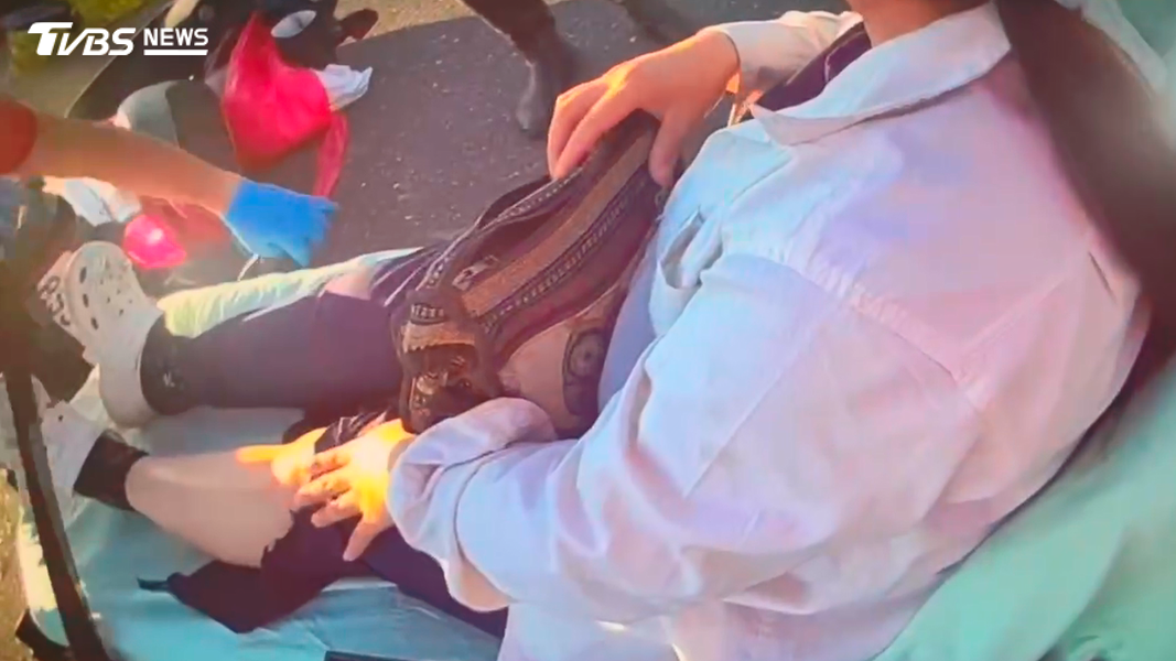 救護人員將跌坐在地的女子攙扶至擔架上送醫治療,所幸女子雖頭部和肢體疼痛,但意識清楚(圖/TVBS)