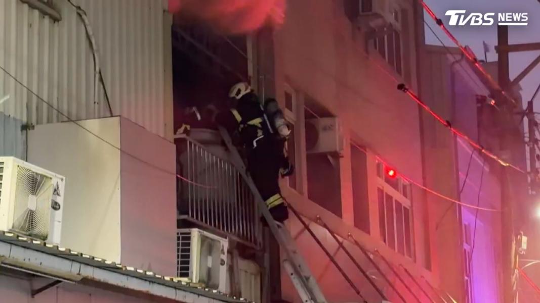 消防人員架梯爬上二樓,確認火勢及是否有人受困,同步在一樓佈水線滅火(圖/TVBS)