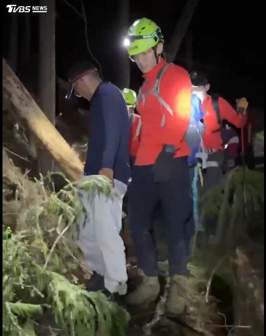 救援人員入夜後將楊女從近乎垂直的邊坡移動至較平坦處，再接力運送下山。（圖／TVBS）