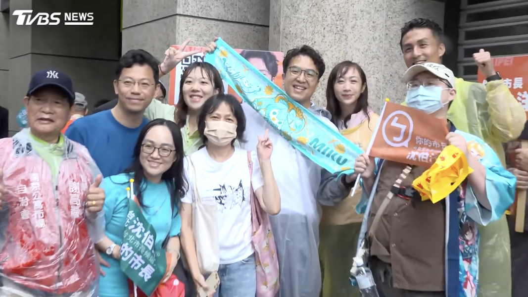沈伯洋在本月6日前往南京公寓市場拜票時,被民眾送上「初音未來」毛巾,合照完後便開心披在自己身上馬上用。(圖/共訊畫面)