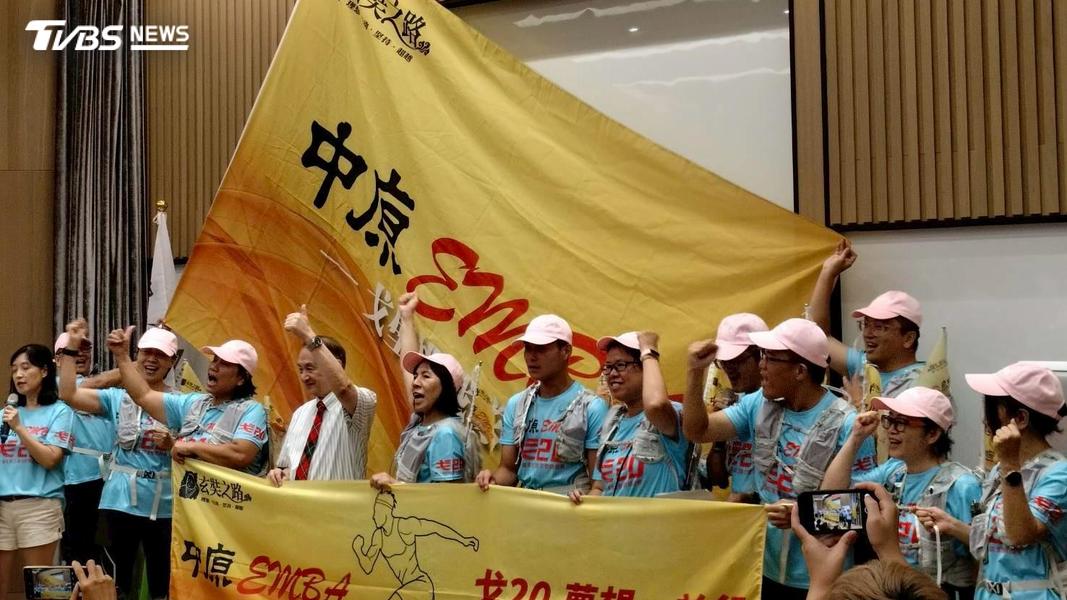 中原EMBA戈20團隊成員高舉隊旗,象徵群體合作與生命連結的教育實踐。(圖/中原大學)