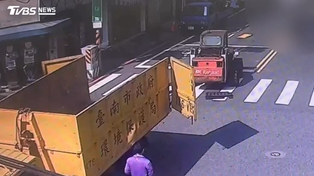 台南一輛環保局清潔車行經路口時,一輛山貓直接從車上掉落路面。(圖/TVBS)