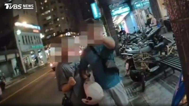 騎士不滿闖紅燈被開單,嗆聲女警「制服脫下來」,還持安全帽逼近。(圖/TVBS)