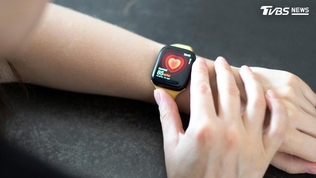 手持Apple Watch Series 8測量心率的女子 (圖/Shutterstock達志影像)