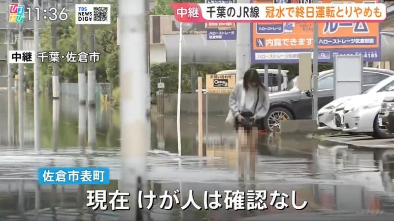 一位女路人路過積水街道,拉高裙子的畫面卻被拍下。(圖/翻攝自推特)