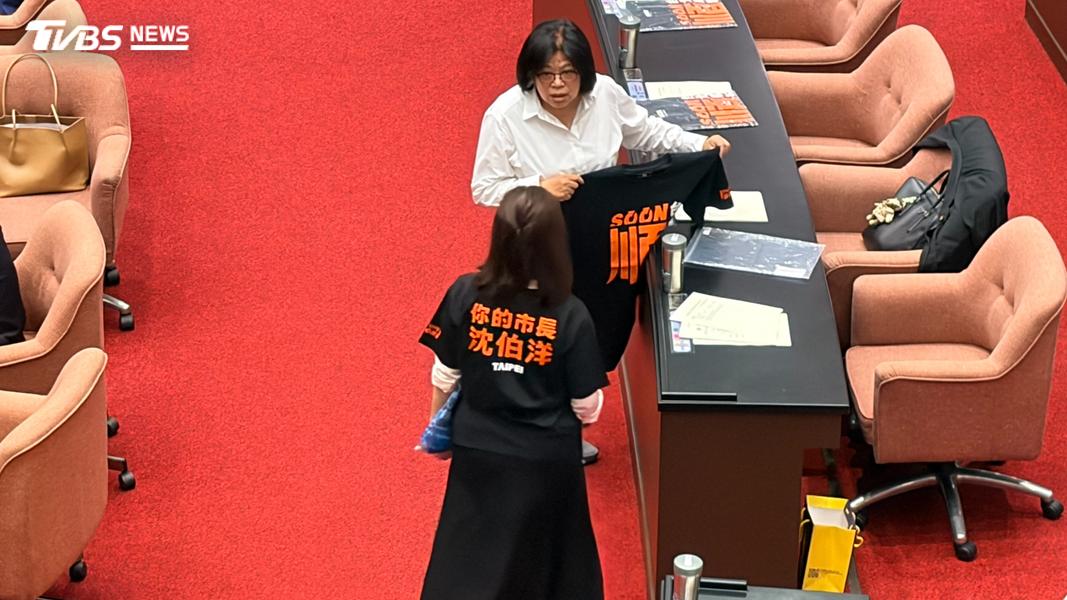 民進黨立委現場套入沈伯洋競選T恤。(圖/傅乙珮攝)