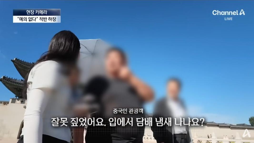 三名吸煙的中國男子轉移焦點並阻撓採訪進行。(圖/翻攝自Channel A)