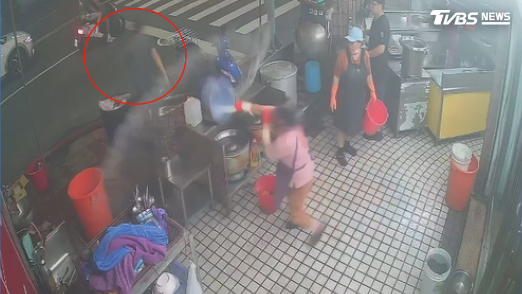 男員工因鴨油潑灑問題與女員工爆發口角,女方提水桶反擊。(圖/TVBS)