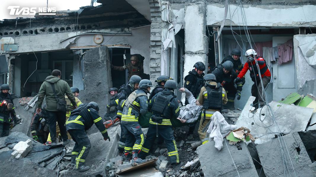 在烏克蘭扎波羅熱,救援人員10日從被俄羅斯空襲摧毀的居民樓廢墟中救出一名婦女。(圖/達志影像美聯社)