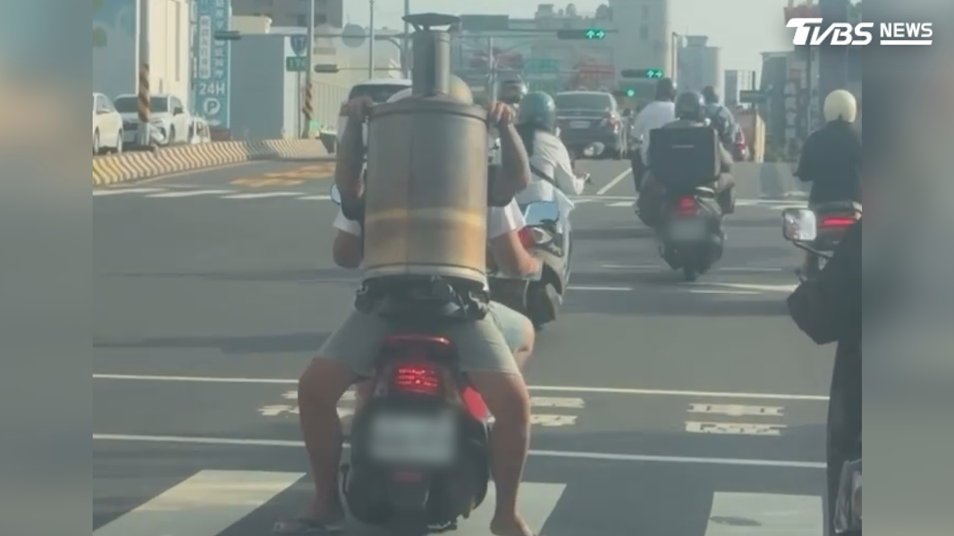 後座乘客以反向乘坐的姿勢,與騎士背靠背,雙手緊抓大金爐,僅靠雙腳夾著機車維持平衡(圖/翻攝Threads@hoh.617)