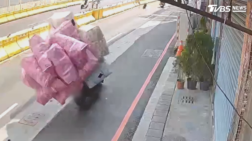 高雄一名騎士將機車掛滿帆布袋,裝得滿滿當當,宛如在掛肉粽一般,行駛在路上速度還不慢(圖/TVBS)