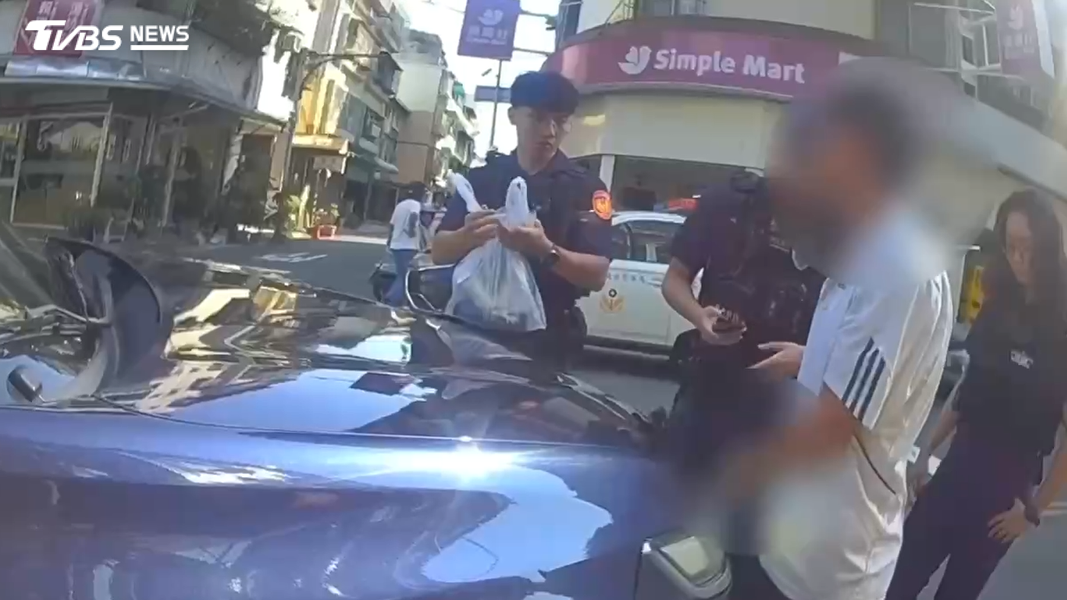 四名員警處理兄弟檔爭執的過程中,一旁身穿白衣的友人雖未參與口角,卻因手中的塑膠袋引起員警注意(圖/TVBS)