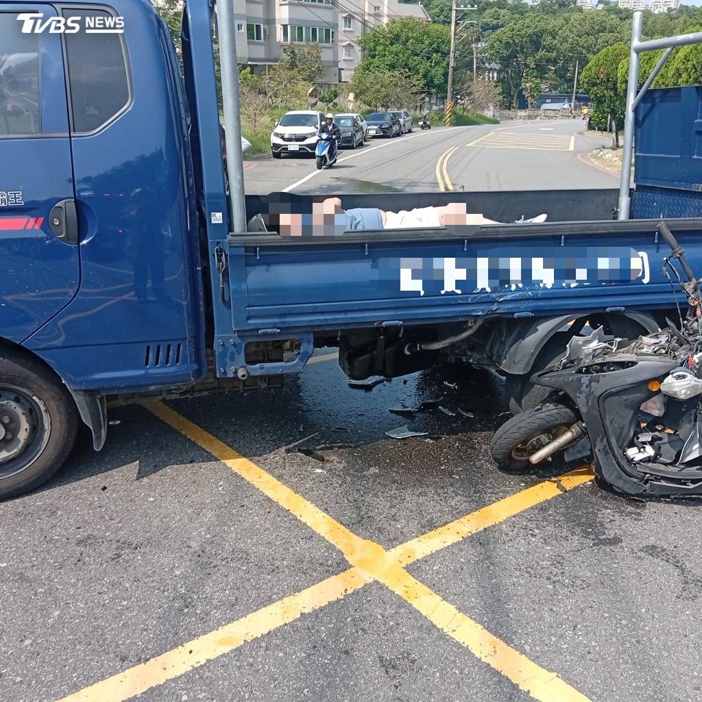 機車倒在貨車旁,車頭嚴重碎裂。(圖/TVBS)
