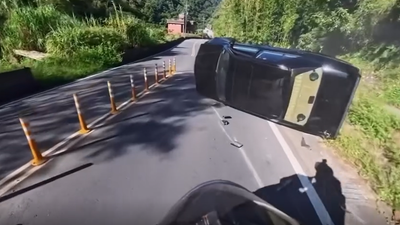 經典名車慘了!駕駛跨雙黃線超車 過彎失控自撞山壁橫躺路邊
