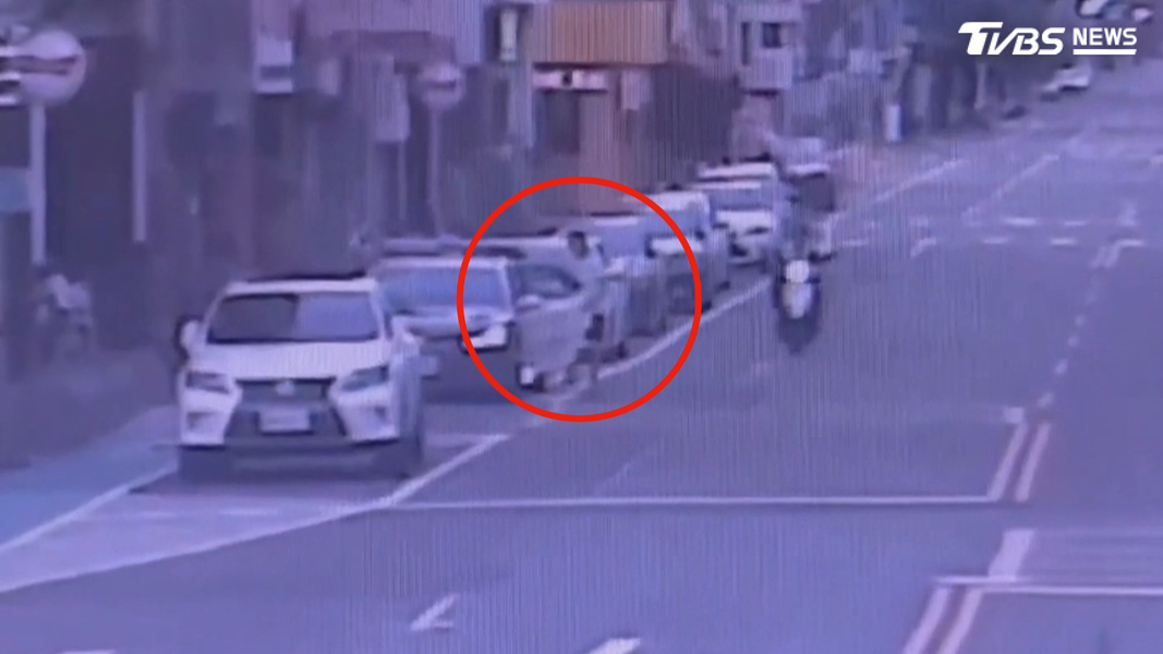 員警發現警車後座有人闖入,立即從駕駛座下車查看,發現身穿白衣的楊姓男子坐在後座(圖/TVBS)