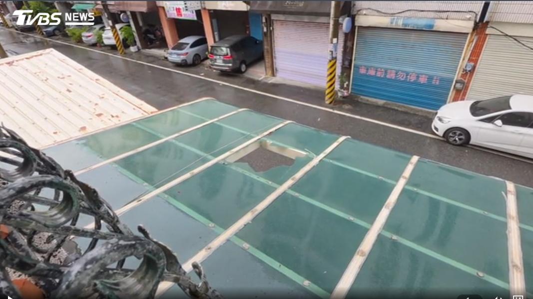 民宅遭突如其來的木板砸破遮陽板。(圖/TVBS)