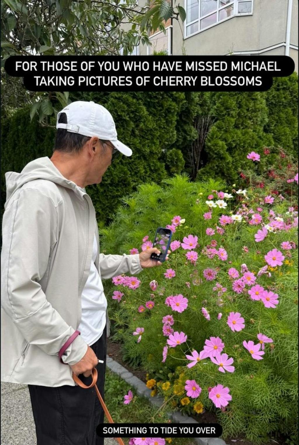 苗僑偉一手牽著愛犬,一手拿著手機拍攝路邊花草。(圖/翻攝自phoebemiu IG)