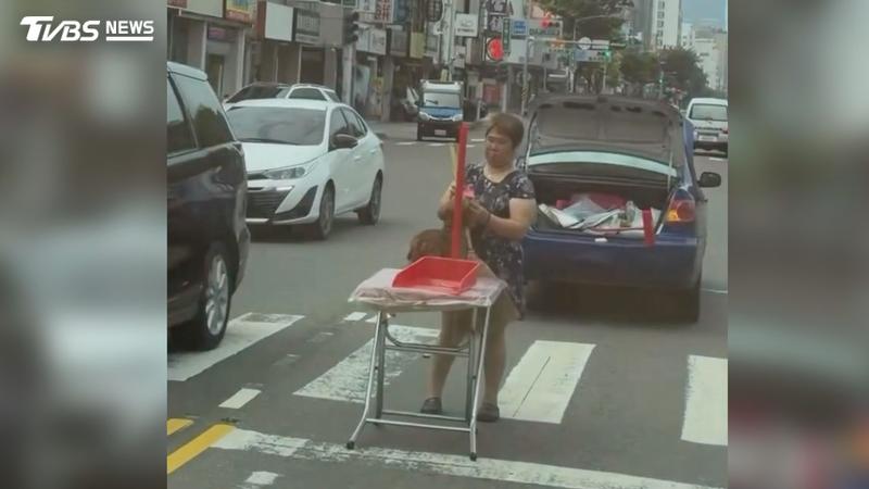 高雄市區三多二路轎車路中拋錨,駕駛擺桌放狗當警示,民眾誤認當街作法。(圖/翻攝Threads_chow.chow__do)