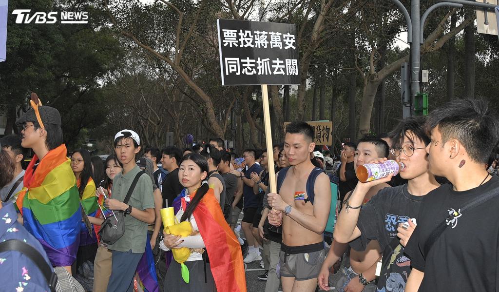 蔣萬安市長到同志遊行，現場民眾高舉「票投蔣萬安，同志抓去關」。(圖／胡瑞麒攝)