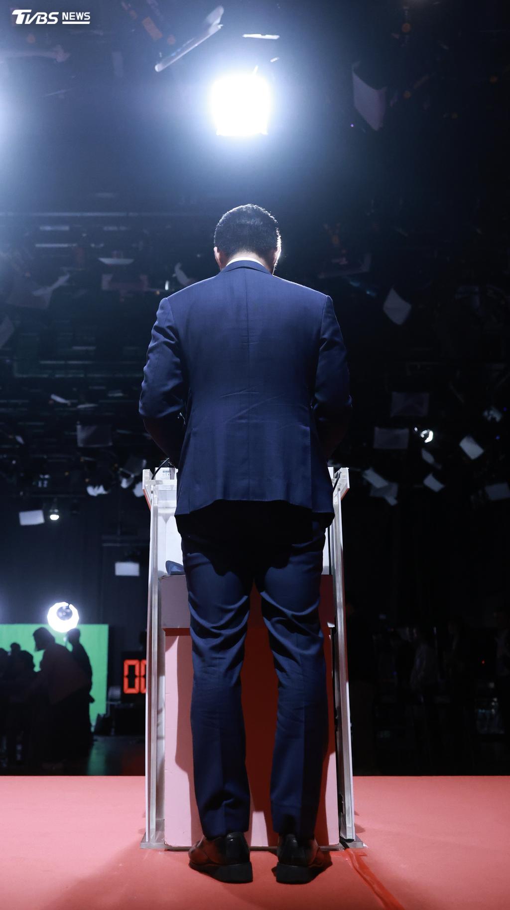 蔣萬安穿著藍西裝出席辯論會，服裝剪裁較為貼身、俐落。（圖／華子琛攝）