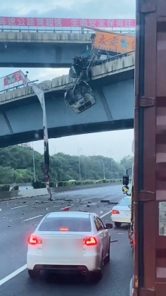 貨車駕駛倒栽蔥受困在車頭,懸掛在國道中山高上方。(圖/翻攝記者爆料網)