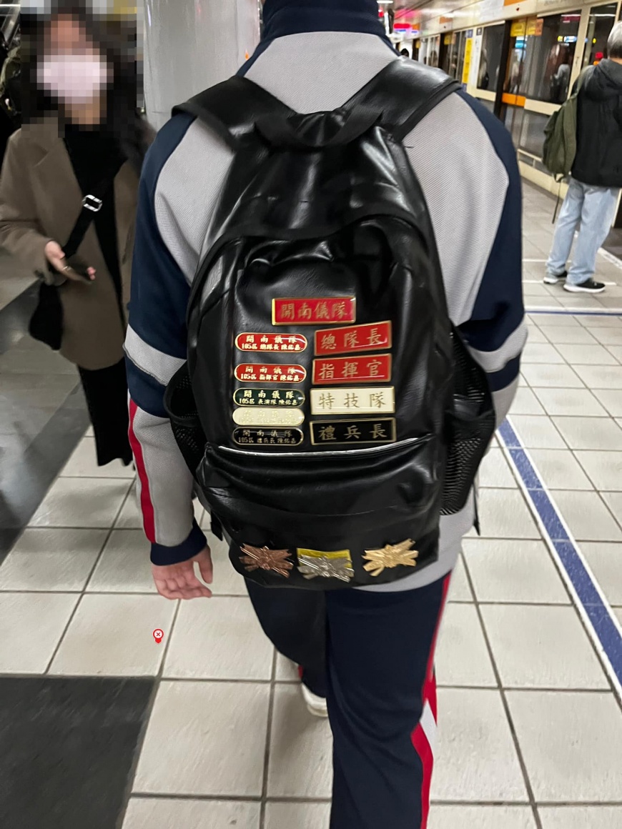 一名男高中生的書包上別滿儀隊總隊長、指揮官等的徽章。(圖/翻攝自路上觀察學院臉書)